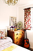 Akustikgitarre und Holzkommode im Schlafzimmer eines Hauses in Birmingham, England UK
