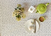 Cut spring flowers and tea with boiled egg on breakfast table in London home   England   UK