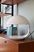 Retro styled heat lamp and books on sideboard in London family home,  England,  UK