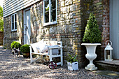 Sitzbank mit Steinmauerwerk und Wetterschutzplatten an der Außenseite eines Hauses im ländlichen Großbritannien