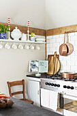 Copper saucepans and chopping boards with recipe book in UK farmhouse kitchen