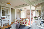 Patterned throw on sofa in open plan living room of UK farmhouse