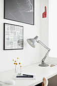 Metallica desk lamp with framed artwork at desk in London home  UK