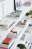 Stacked magazines ordered onto open shelving in London apartment  UK