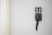 Schwarze Katzenuhr an weißer Wand in einem Haus in Alloa, Schottland, UK