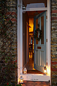 Beleuchtete Laternen und offene Tür mit Blick in ein Londoner Haus UK
