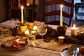 Lit candles and wineglasses on dining table in London home  UK