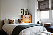 Wooden chest of drawers beside double bed in Rochester home  Kent  UK