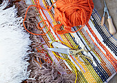 Ball of wool and scissors with rag rug in London home  UK