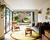 Braunes Ledersofa mit Ablagekörben im Wohnzimmer eines Stadthauses im Osten Londons, England UK