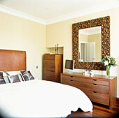 Doppelschlafzimmer mit maßgefertigter Kommode aus Nussbaumholz und verziertem Spiegelrahmen