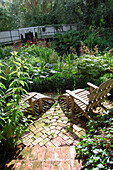 Outdoor chairs on brick patio in garden