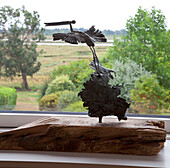 Abstract bird sculpture and driftwood on windowsill in Essex home UK