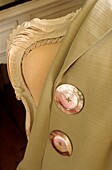 Close up of mother of pearl buttons on cream jacket on fauteuil