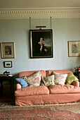 Rosa gepolstertes Sofa mit Porträtgemälde im Wohnzimmer