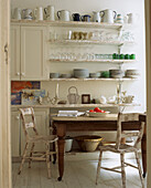 China and glass stacked on open shelves in the light and airy breakfast room