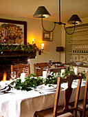 A festive table set for christmas dinner in a fire lit dining room