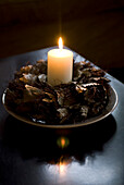 Lit candle with wreath of leaves