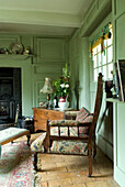 Armchair in front of green panelled living room door