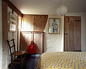 Gefleckter Bettbezug in einem ländlichen Schlafzimmer mit Holzschränken
