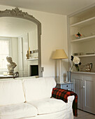 Weißes Sofa im Wohnzimmer mit übergroßem Spiegel, in dem sich eine Cäsar-Büste spiegelt, und original edwardianischem Wandschrank