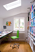 Weißes Arbeitszimmer mit Schreibtisch, Bücherregal und lindgrünem Stuhl
