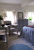 Floral patterned armchair in bedroom with low ceiling