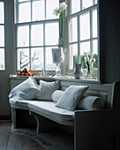 Weiße Holzbank mit Kissen neben dem Fenster im Esszimmer