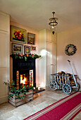 Lit fire with crate of holly and firewood in trolley cart