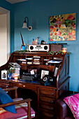 Writing bureau with blue wall and floral artwork