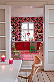 Blick durch Flügeltüren in eine mit Blumentapeten tapezierte Küche in Odense