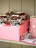Tassenkuchen auf einer rosa Schachtel mit Flockenbelag