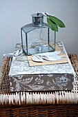 Glass lantern with leaves on gift box with hamper