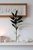 Sprig of leaves on mantlepiece with white ornaments in Richmond home