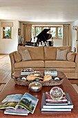 Flügel und zweisitziges Sofa mit Couchtisch und Büchern in einem Haus in Canterbury, England UK