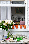 White roses on garden table of whitewashed London home, UK