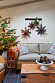 Sternförmige Weihnachtsdekoration und Baum im Wohnzimmer eines Hauses in Walberton, West Sussex, England, UK