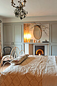 Cream bedspread in room with lit candles, Walberton home, West Sussex, England, UK