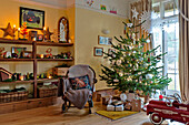 Christmas tree and rocking chair with shelving in Forest Row family home, Sussex, England, UK