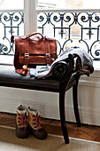 Brown leather satchel on window seat in Paris apartment, France