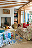 Beamed living room with wood burning stove in Essex home, England, UK