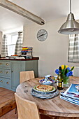 Cut flowers and quiche on wooden table in Suffolk farmhouse kitchen, England, UK