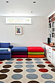 Bodenkissen mit gepunktetem Teppich im Spielzimmer eines modernen Hauses, Cornwall, England, UK