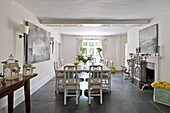 Weißer Esstisch und Stühle mit modernen Kunstwerken in einem modernen Haus in Suffolk/Essex, England, UK