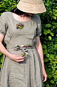 Woman in sunhat collecting wildflowers in Brecon, Powys, Wales, UK