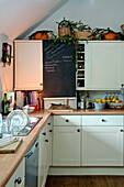 Kreidetafel in weißer Einbauküche in einem Cottage in Shropshire, England, Vereinigtes Königreich