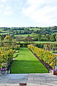 Paved patio and lawned exterior of garden in rural countryside, Blagdon, Somerset, England, UK