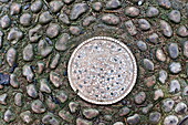 Garden mosaic in cobblestone garden path, Blagdon, Somerset, England, UK