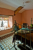 Brass footboard with Christmas decorations and patterned rug in peach bedroom of Tregaron home Wales UK