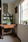 Spring bulbs in planter on wooden side table at window in Sherford barn conversion Devon UK